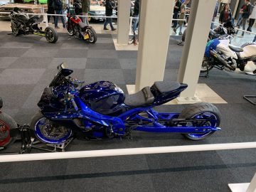 Een blauwe motorfiets geparkeerd in een showroom op Auto Live 2019.