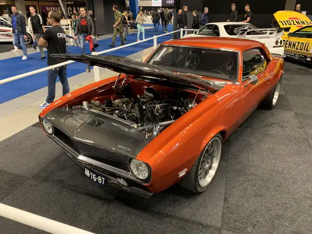 Een oranje muscle car is te zien op de 100% Auto Live 2019-show.