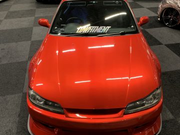 Een rode sportwagen staat geparkeerd in een showroom tijdens de Auto Live 2019.