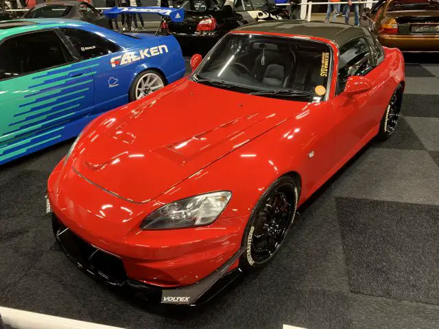 Een rode sportwagen staat geparkeerd in een showroom tijdens het Auto Live-evenement van 2019.