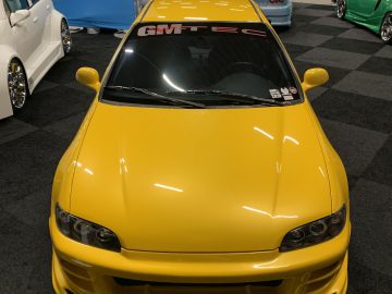 Een gele auto is te zien op de show 100% Auto Live 2019.