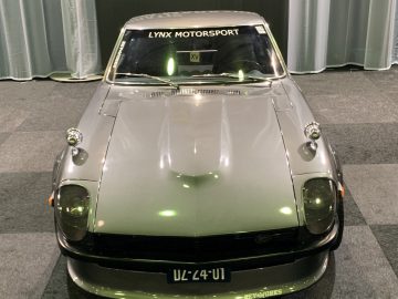 Tijdens het evenement Auto Live 2019 is een zilveren sportwagen te zien in een zaal.