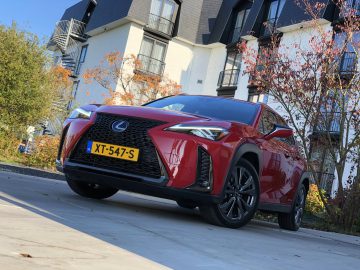 De Lexus UX SUV staat geparkeerd voor een gebouw.
