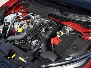 Het motorcompartiment van een rode Nissan Juke.