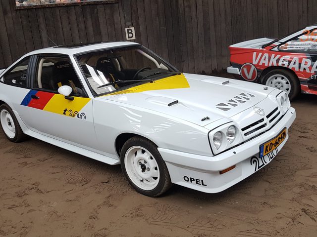 Een wit-gele Opel staat geparkeerd naast een andere auto bij het Opel 400 Treffen 2019.