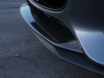 Een close-up van de voorbumper van een grijze Jaguar-auto.