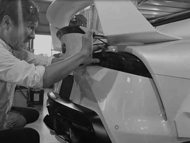 Een man werkt aan een witte Toyota-sportwagen.