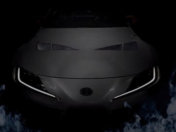 Een zwarte Toyota-sportwagen waar rook uit komt.