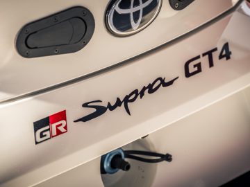 De achterkant van een witte Toyota GR Supra GT4.