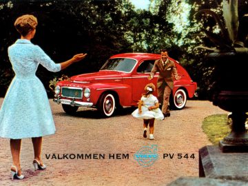 Een vrouw en een kind, staande voor een rode auto, doen gordels aan.