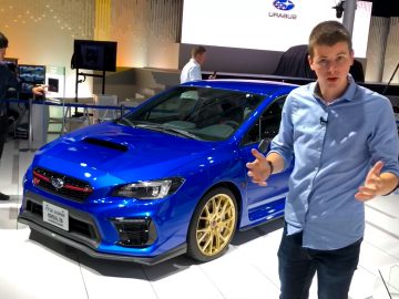 Een man staat naast een blauwe Subaru WRX op de Tokyo Motor Show.