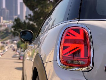 Een witte elektrische auto mini-cooper met een Britse vlag op het achterlicht.