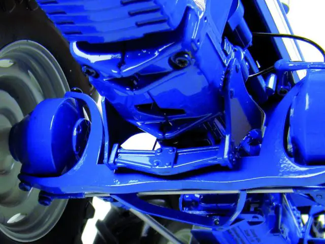 Een close-up van de voorkant van een blauwe tractor uit County 654.