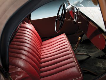 Een rood lederen stoel in een Velorex-auto.