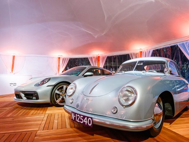 Twee vintage Porsche 911 auto's geparkeerd in een tent.