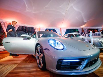 In een tent staat een Porsche 911 gts tentoongesteld.