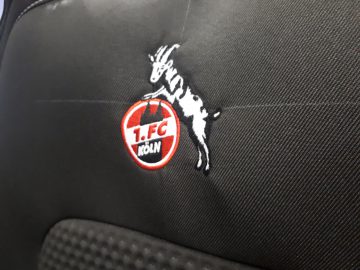 Een zwarte Ford-auto met het logo van een geit erop.