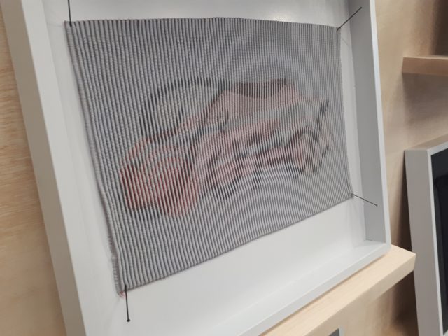 Een ingelijst Ford-designkunstwerk met het woord 'Ford' erop.
