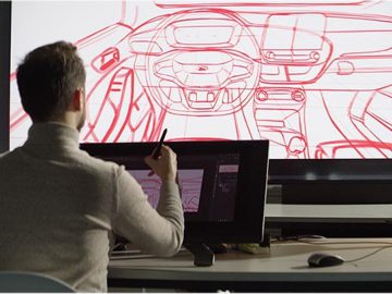 Een man tekent een Ford-ontwerp op een scherm in een kantoor.
