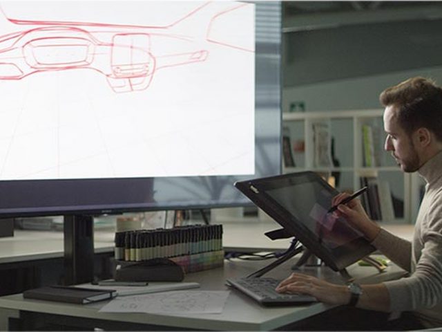 Een man tekent een Ford-ontwerp op een groot scherm in een kantoor.