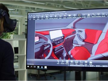 Een man met een virtual reality-headset kijkt naar een afbeelding van een Ford-auto-ontwerp.