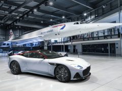 De Aston Martin Concorde staat geparkeerd voor een vliegtuig.