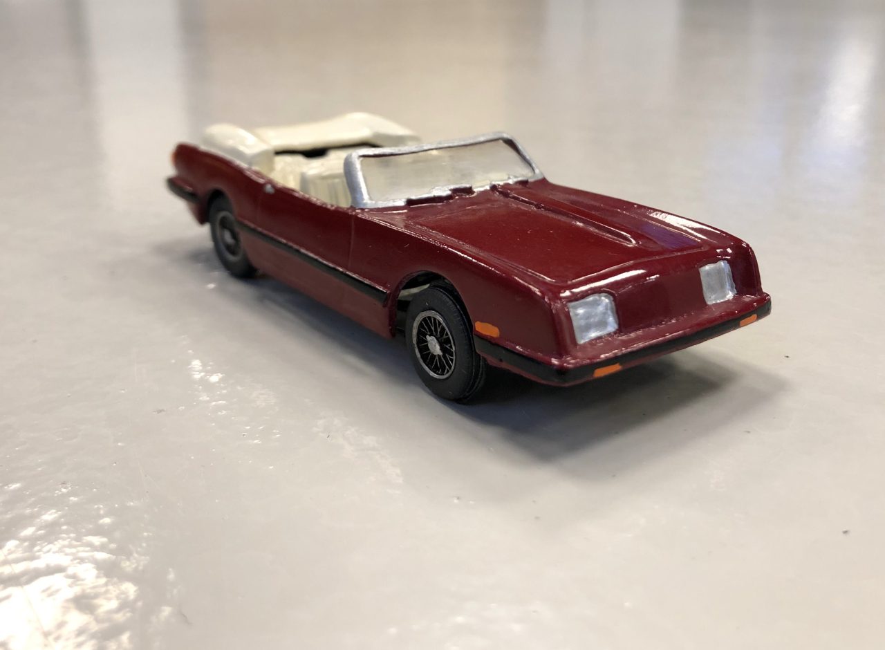 Een rood Morris J Van-speelgoed op een wit oppervlak.