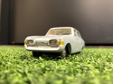 Een Morris J Van-speelgoed staat geparkeerd op het gras.