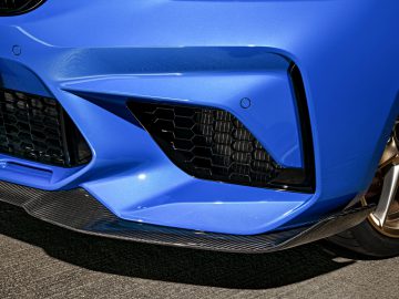 De voorkant van een blauwe BMW M2 CS.