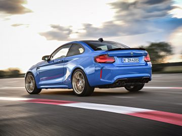 De blauwe BMW M2 CS coupé rijdt op een circuit.
