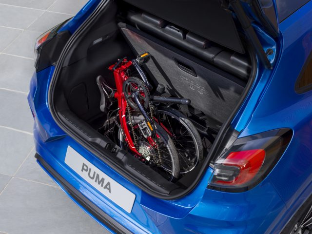 Een blauwe Ford Puma met een fiets in de kofferbak.
