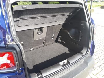 De achterkant van een blauwe Renegade SUV met de kofferbak open.