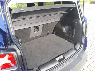De kofferbak van een blauwe Renegade SUV met de kofferbak open.