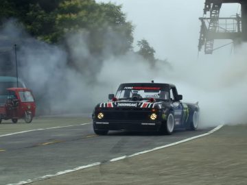 Een vrachtwagen die over een weg rijdt waar rook uit komt, bestuurd door Ken Block.