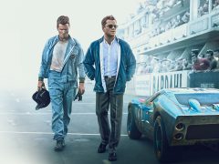 Twee mannen staan naast een auto voor het circuit van Le Mans 66.