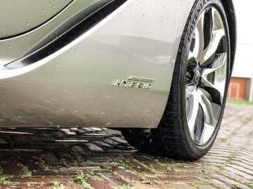 Een close-up van een zilverkleurige Lexus LC 500h op een steenweg.