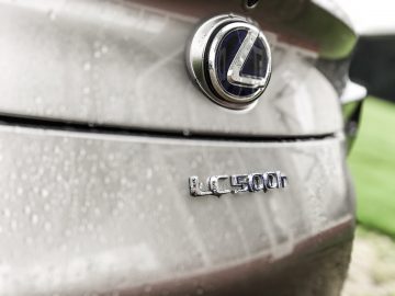 Een close-up van een Lexus LC 500h-badge op een auto.