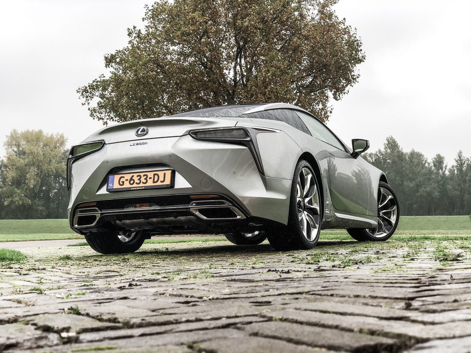De achterkant van een zilveren Lexus LC 500h.