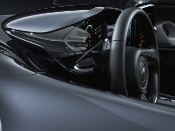 Het interieur van een McLaren Elva-sportwagen met stuur en dashboard.