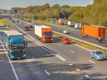Een vrachtwagen rijdt op een snelweg en vermijdt ongevallen.