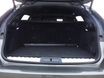 De kofferbak van een Peugeot 508 met daarin een luidspreker.