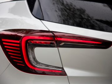 Een close-up van de achterlichten van een witte Renault Captur.