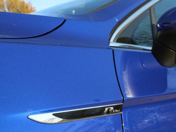 Een close-up van een blauwe Volkswagen Passat Variant autodeurkruk.
