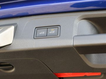 Een blauwe Volkswagen Passat Variant met een rode knop op het dashboard.
