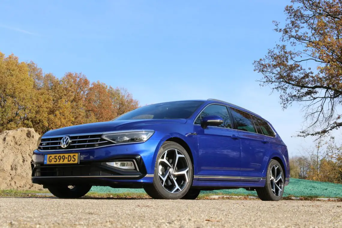 A blue Volkswagen Passat Variant parked on a dirt road.