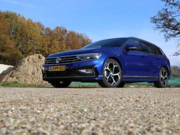 Een blauwe Volkswagen Passat Variant geparkeerd op een onverharde weg.