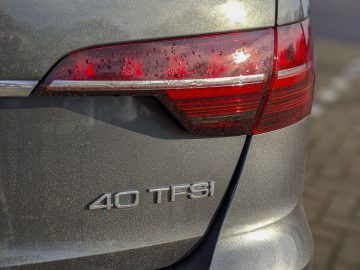 Een zilveren Audi A4 Avant met een sticker op de achterkant.