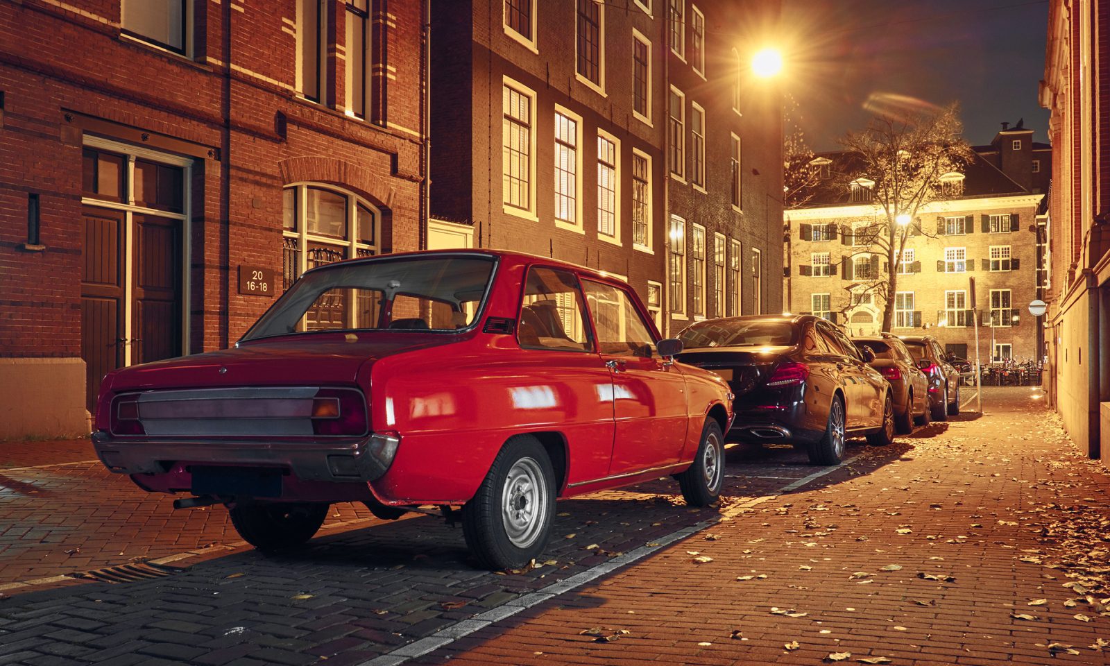 Een rode personenauto geparkeerd op een straat in Nederland.