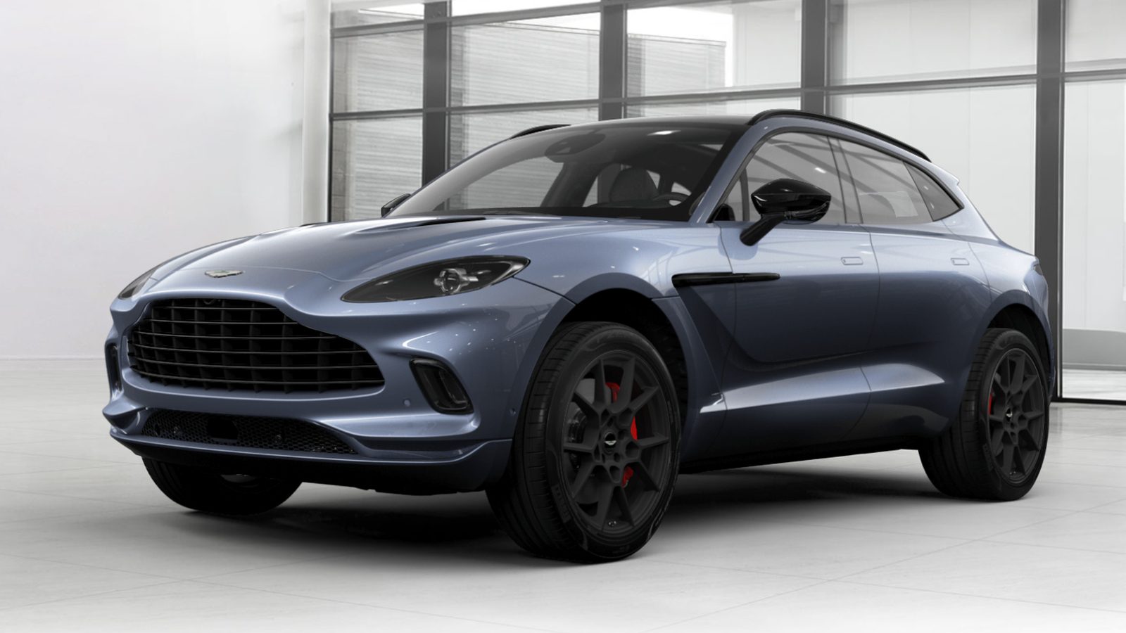 Een blauwe Aston Martin DBX SUV uit 2020 geparkeerd in een kamer.