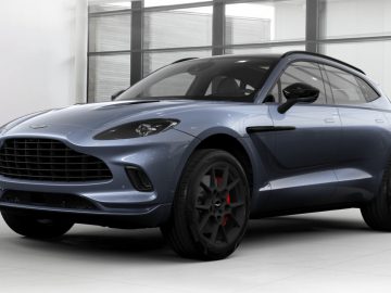 Een blauwe Aston Martin DBX SUV uit 2020 geparkeerd in een kamer.